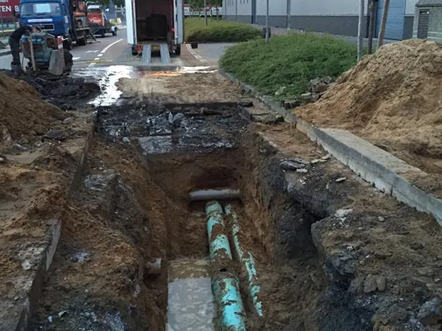 Geopende sleuf in het wegdek met de herstelde ringleiding op industrieterrein Heide-Roerstreek