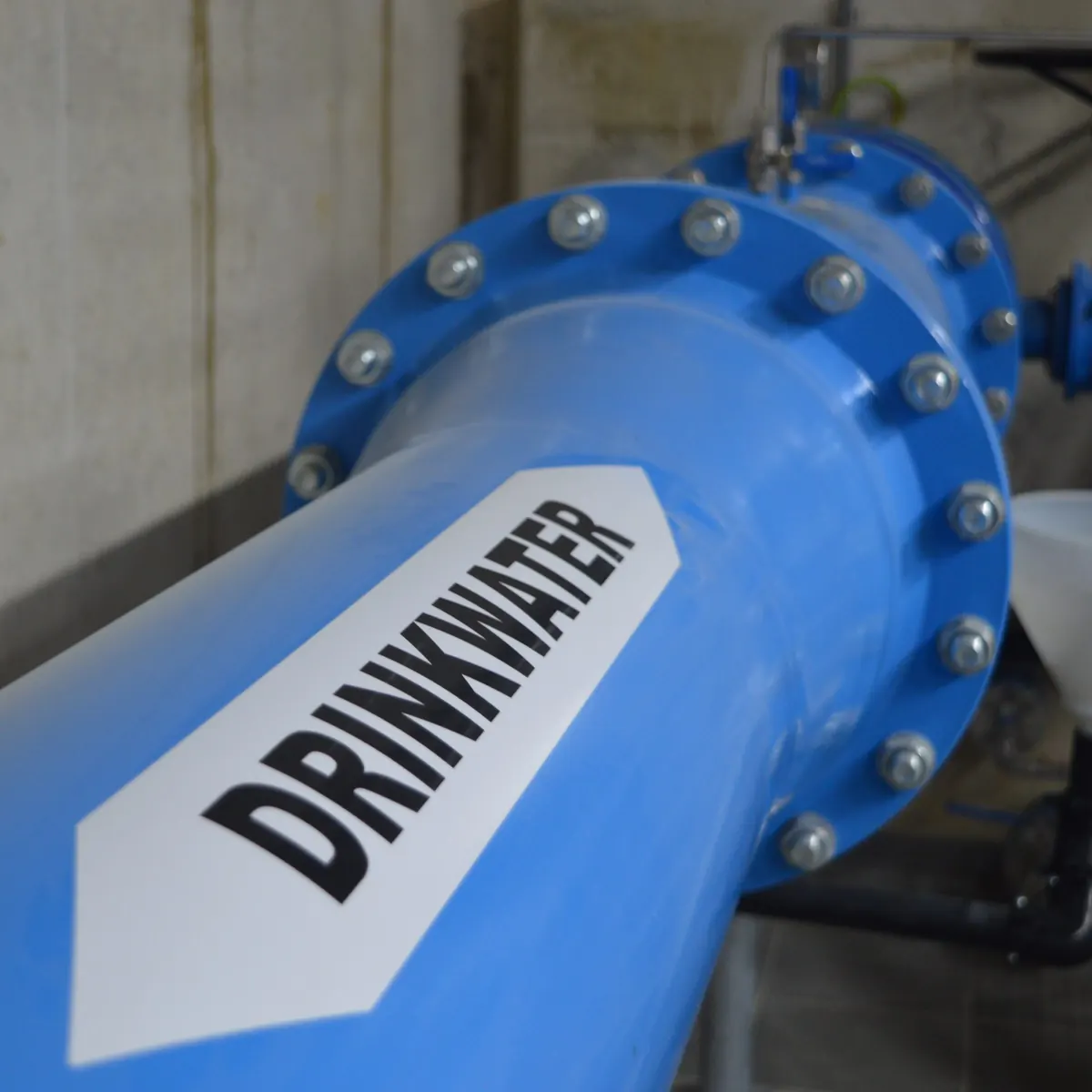 Blauwe drinkwaterleiding met flenzen en een pijlvormige markering DRINKWATER