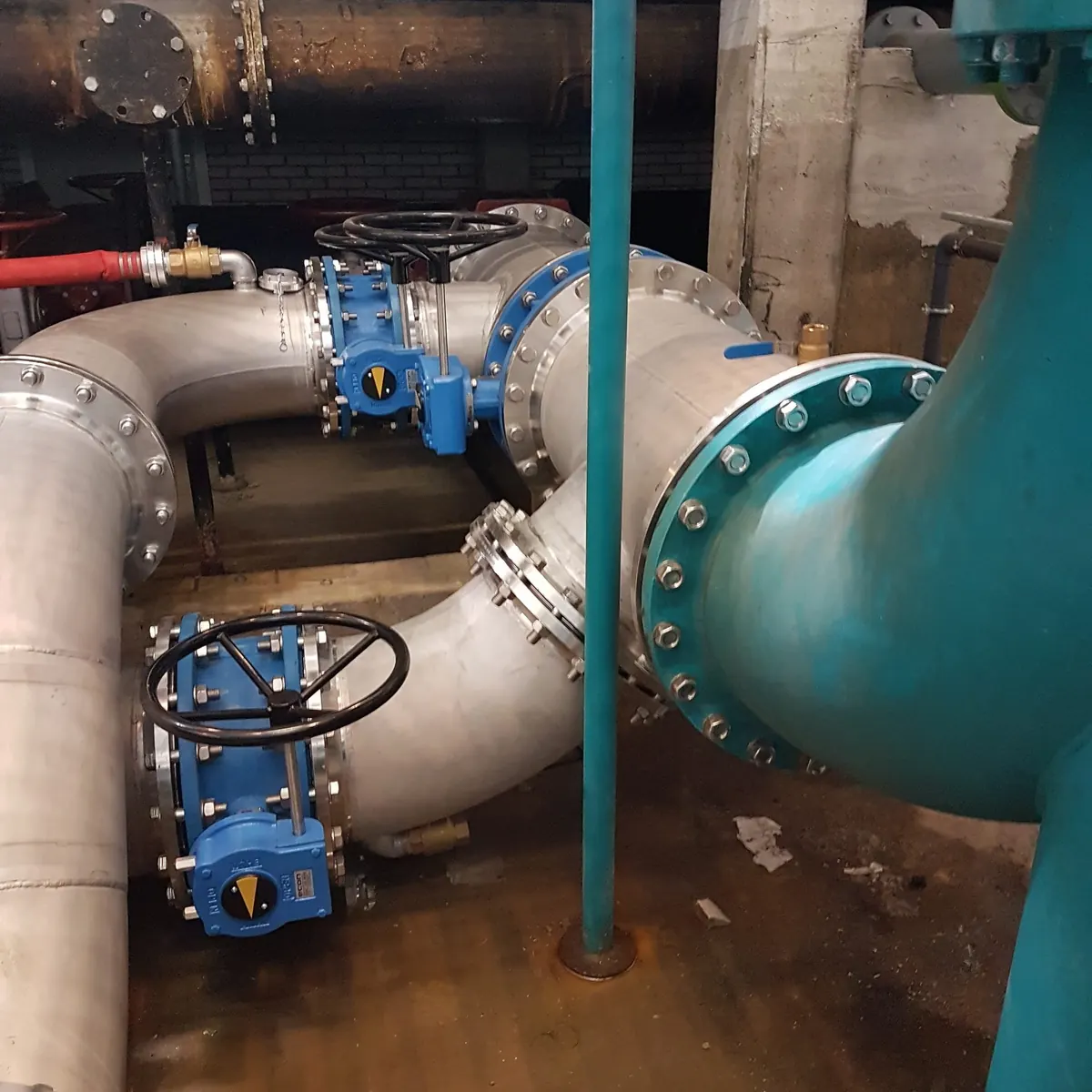 RVS-leidingwerk met blauwe afsluiters in een pompruimte